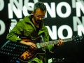 [Zdjęcie z koncertu. Gitarzysta w zielonej kurtce gra na instrumencie. Na twarzy artysty widoczne skupienie. W tle napisy "No" nałożone na siebie.]