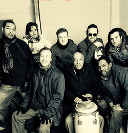 Czarno-biała fotografia Mulatu Astatke i członków The Ukulele Orchestra.